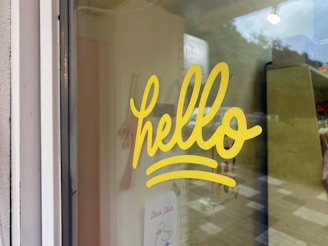 A close-up of a window decal featuring crisp vinyl lettering on a glass door, catching the morning light.