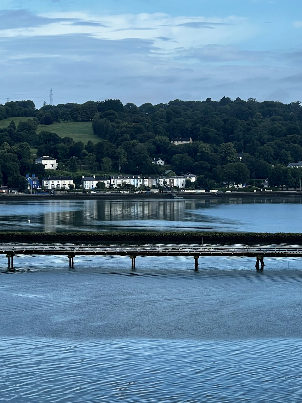 a large body of water sitting next to a lush green hillside