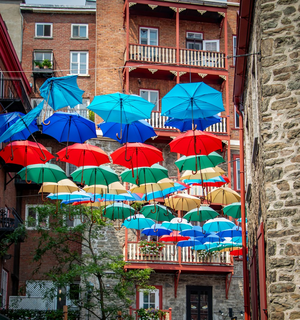a bunch of umbrellas hanging from the side of a building