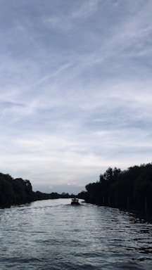 A serene inland waterway with a sleek autonomous vessel gliding smoothly under a clear sky.