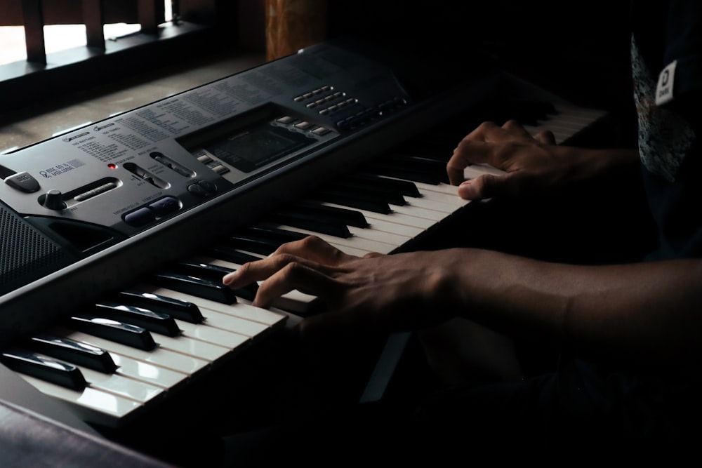 a person sitting at a keyboard with their hands on it