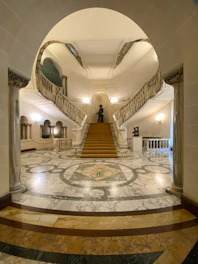 An upscale Dubai lobby featuring a grand marble staircase with intricate veining.