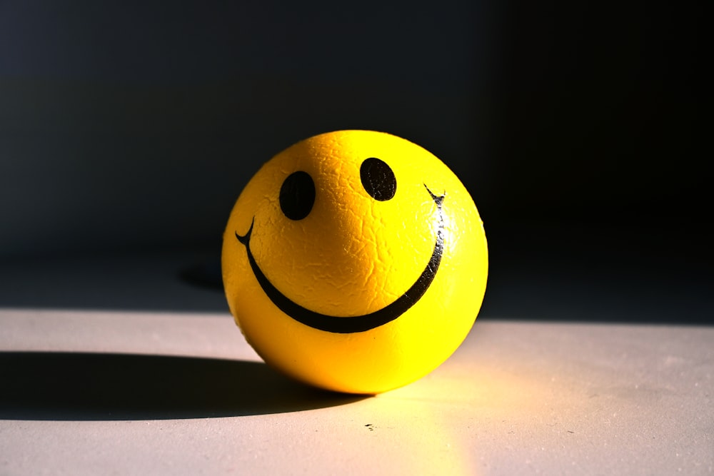 a yellow smiley face ball sitting on a table