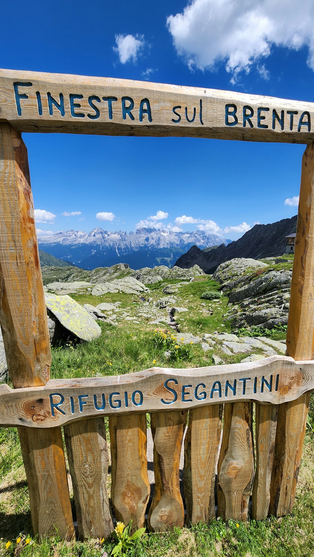 a wooden sign sitting on top of a lush green field