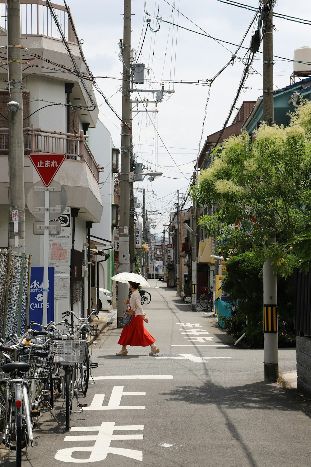 a woman walking down a street holding an umbrella