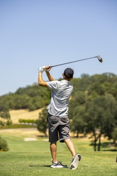 a man swinging a golf club on a golf course
