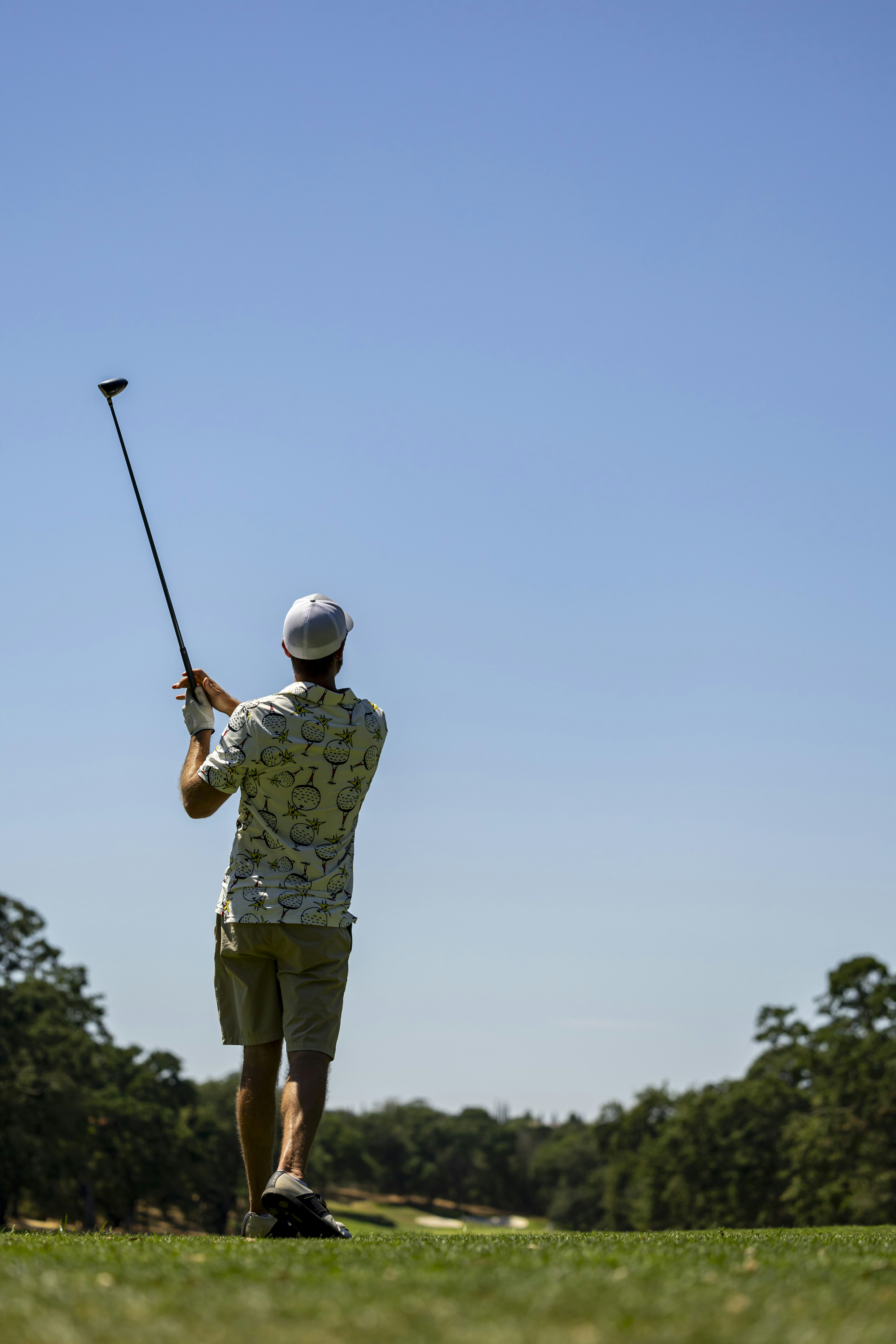 A man swinging a golf club on a golf course photo Free Field Image on Unsplash