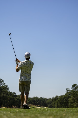 Friends enjoying a round of golf under a clear blue sky.