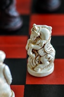 Close-up of a finely painted knight figurine on a sleek chessboard.