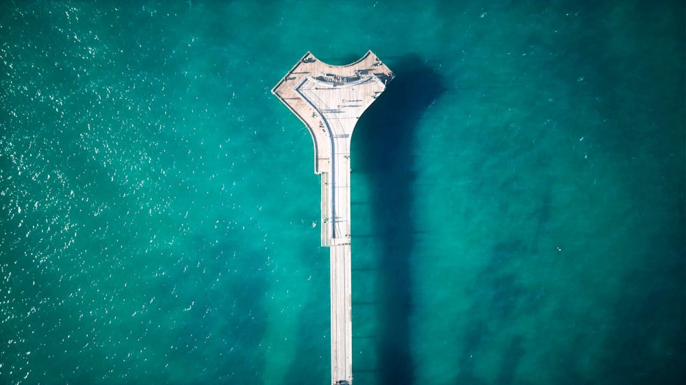 an aerial view of a pier in the middle of the ocean