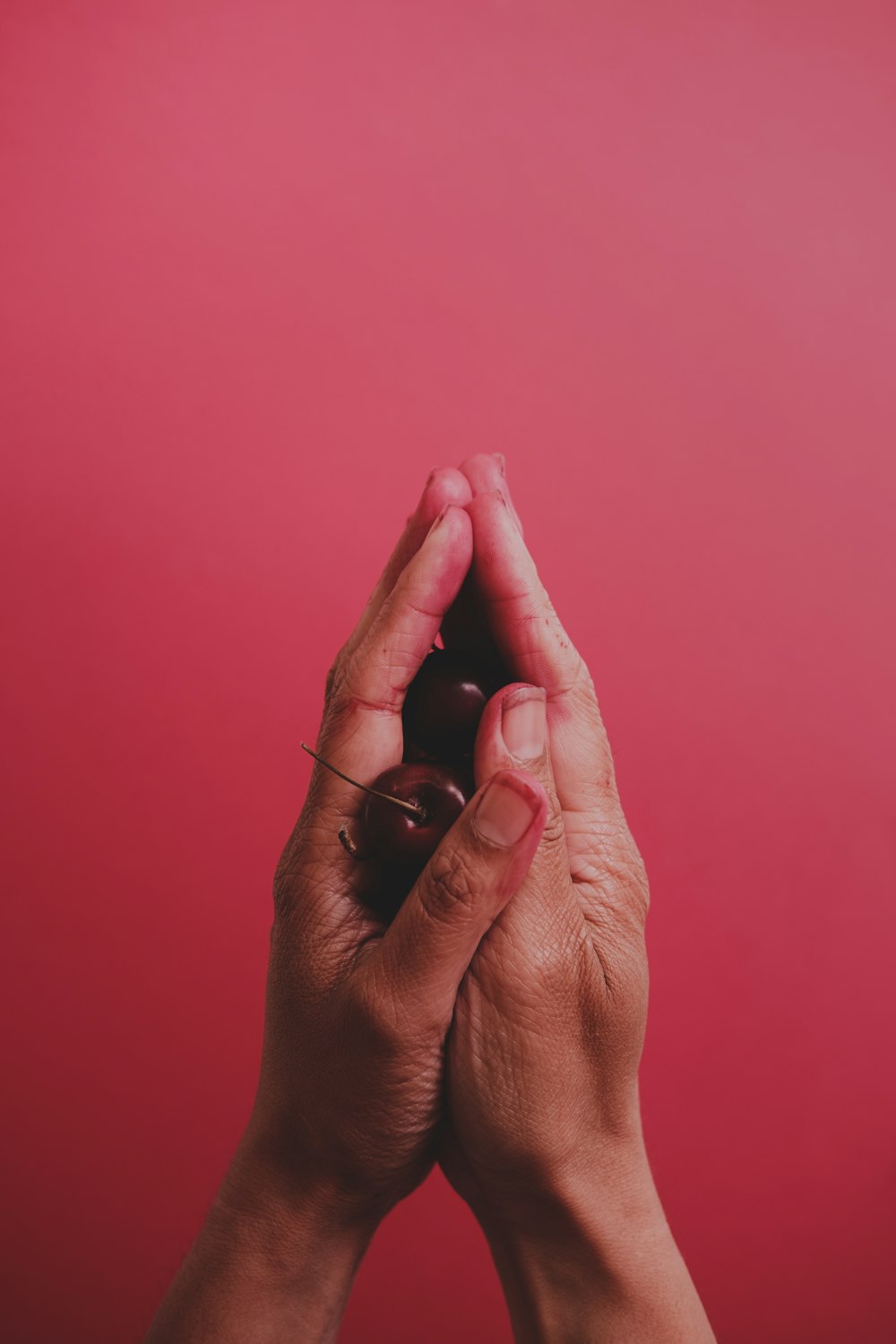 a person holding their hands together with a red background