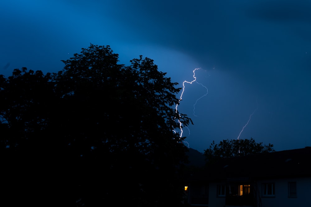 a lightning bolt is seen in the sky above a house