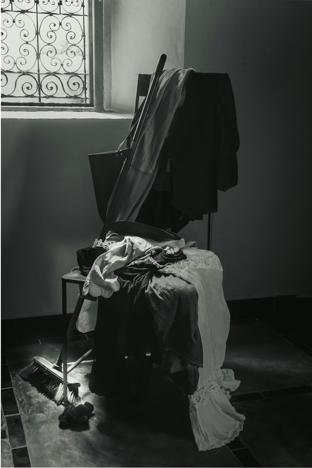 a black and white photo of a chair and clothes