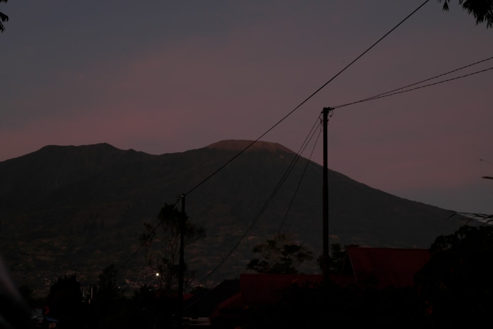 a mountain in the distance with power lines in the foreground