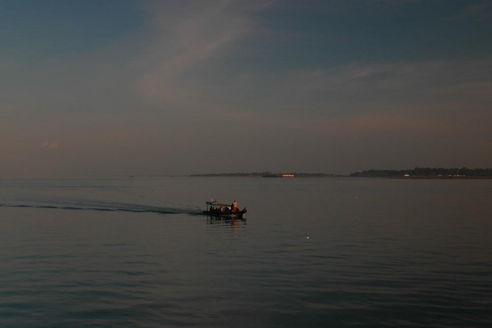 a small boat traveling across a large body of water