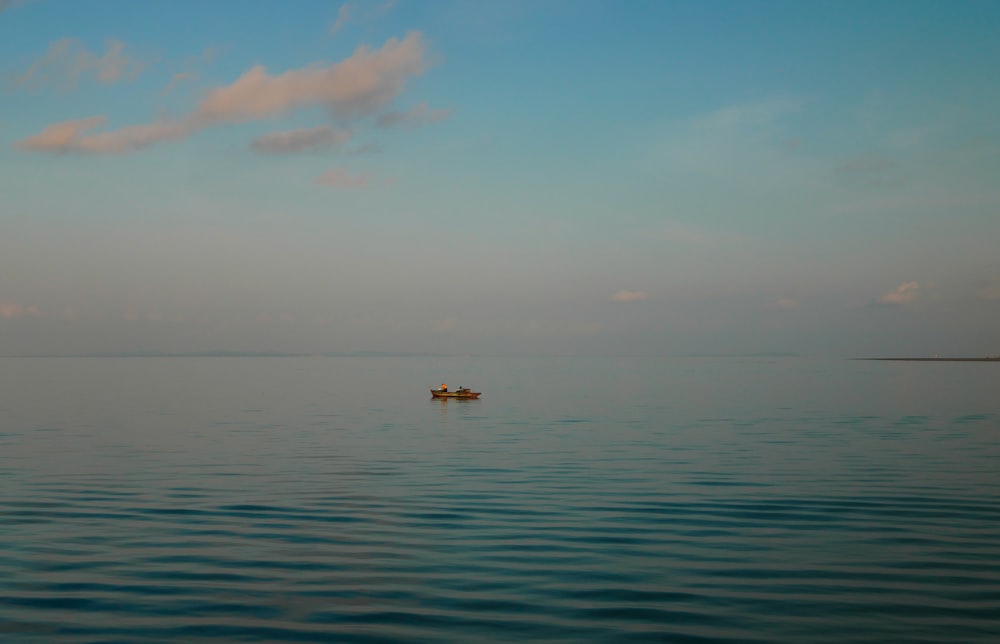 a small boat floating on top of a large body of water