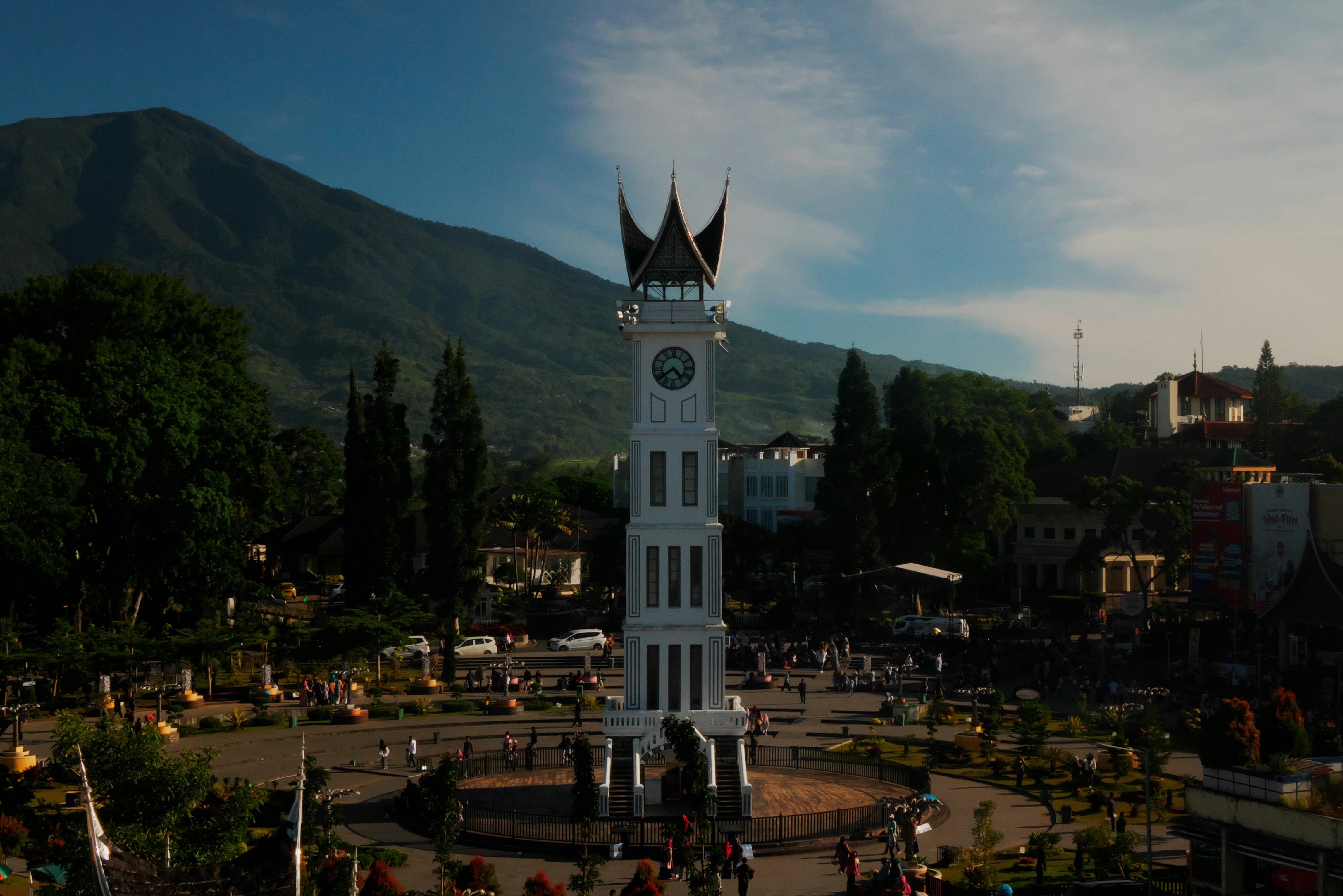 a large white clock tower sitting in the middle of a park