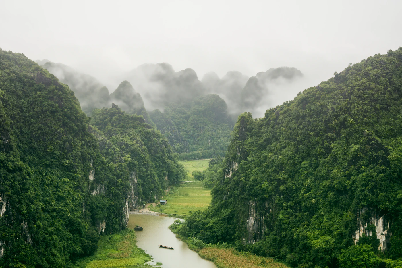 Misty limestone mountains and a calm river in Ninh Bình