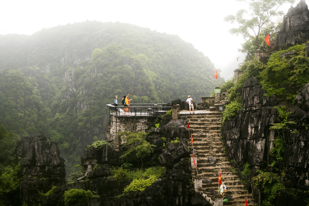 a group of people standing on top of a cliff