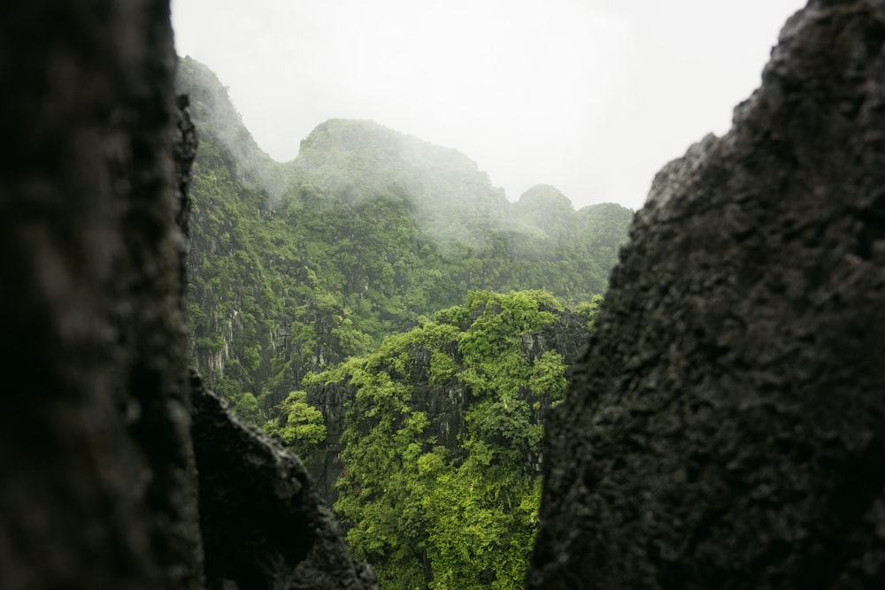 a view of a mountain range through a hole in a rock