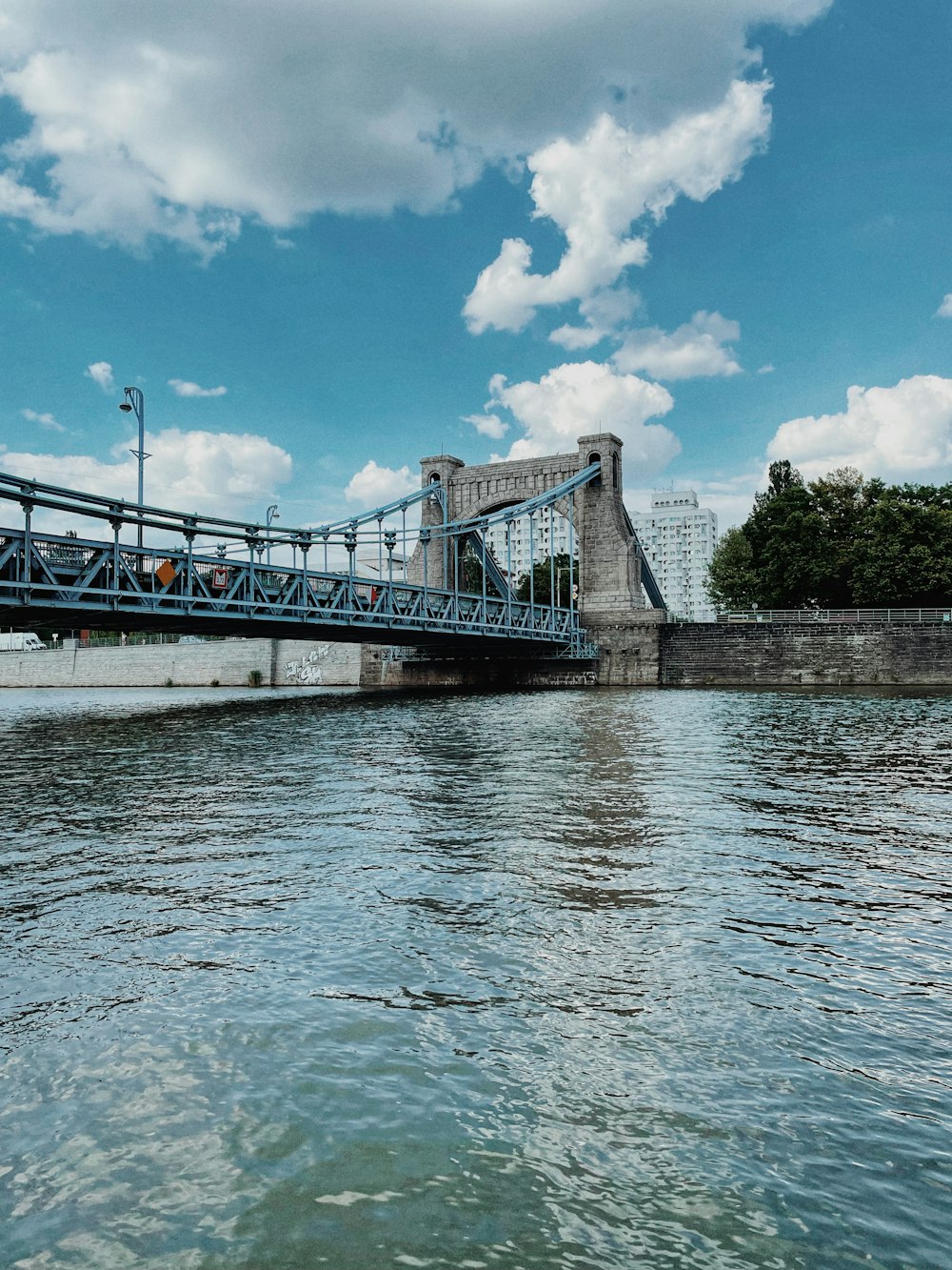 a bridge over a body of water under a cloudy blue sky