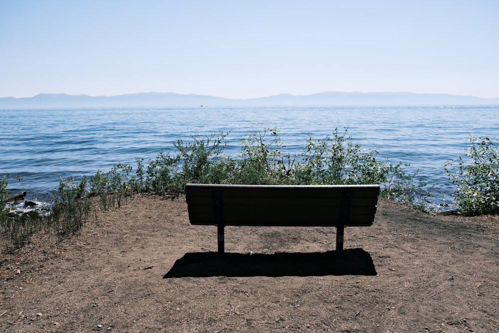 a bench sitting on top of a sandy beach