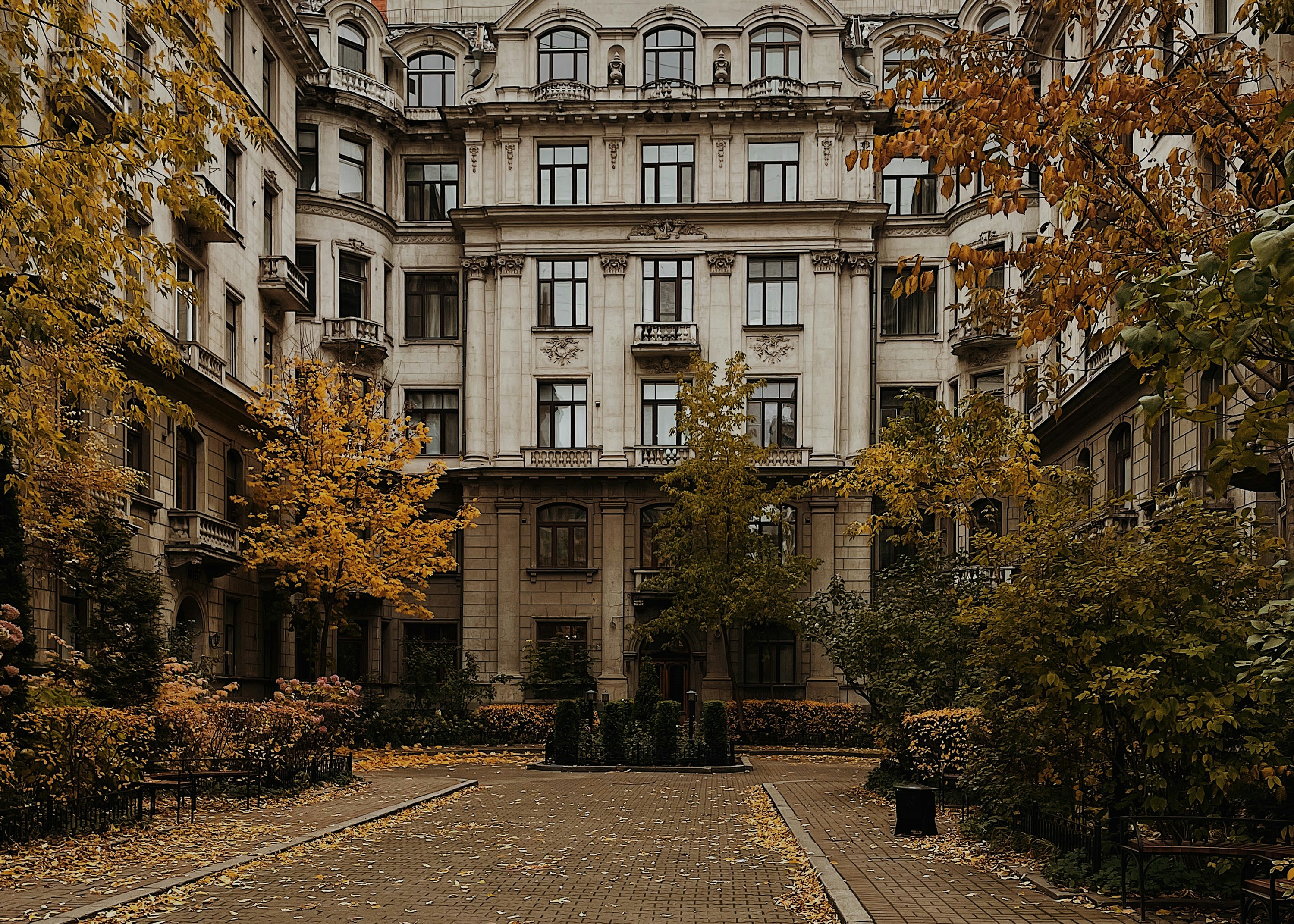Ein großes Gebäude mit vielen Fenstern und vielen Bäumen