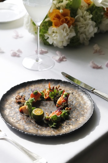 a plate of food on a table with a glass of wine