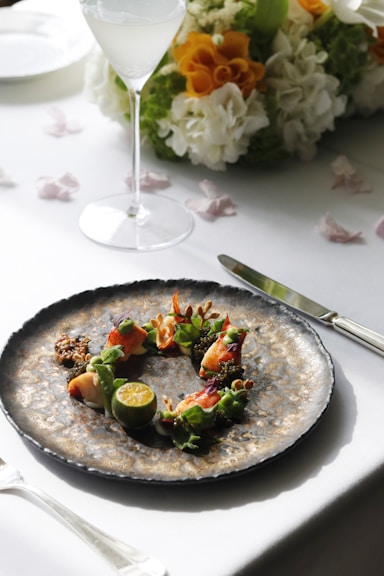a plate of food on a table with a glass of wine