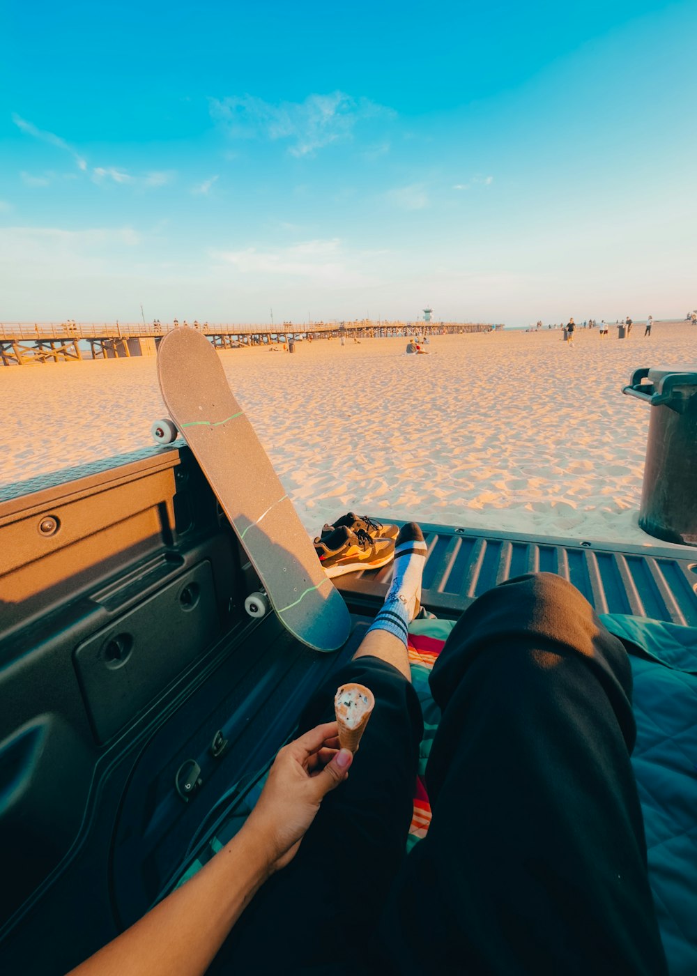 a person laying in the back of a truck on a beach