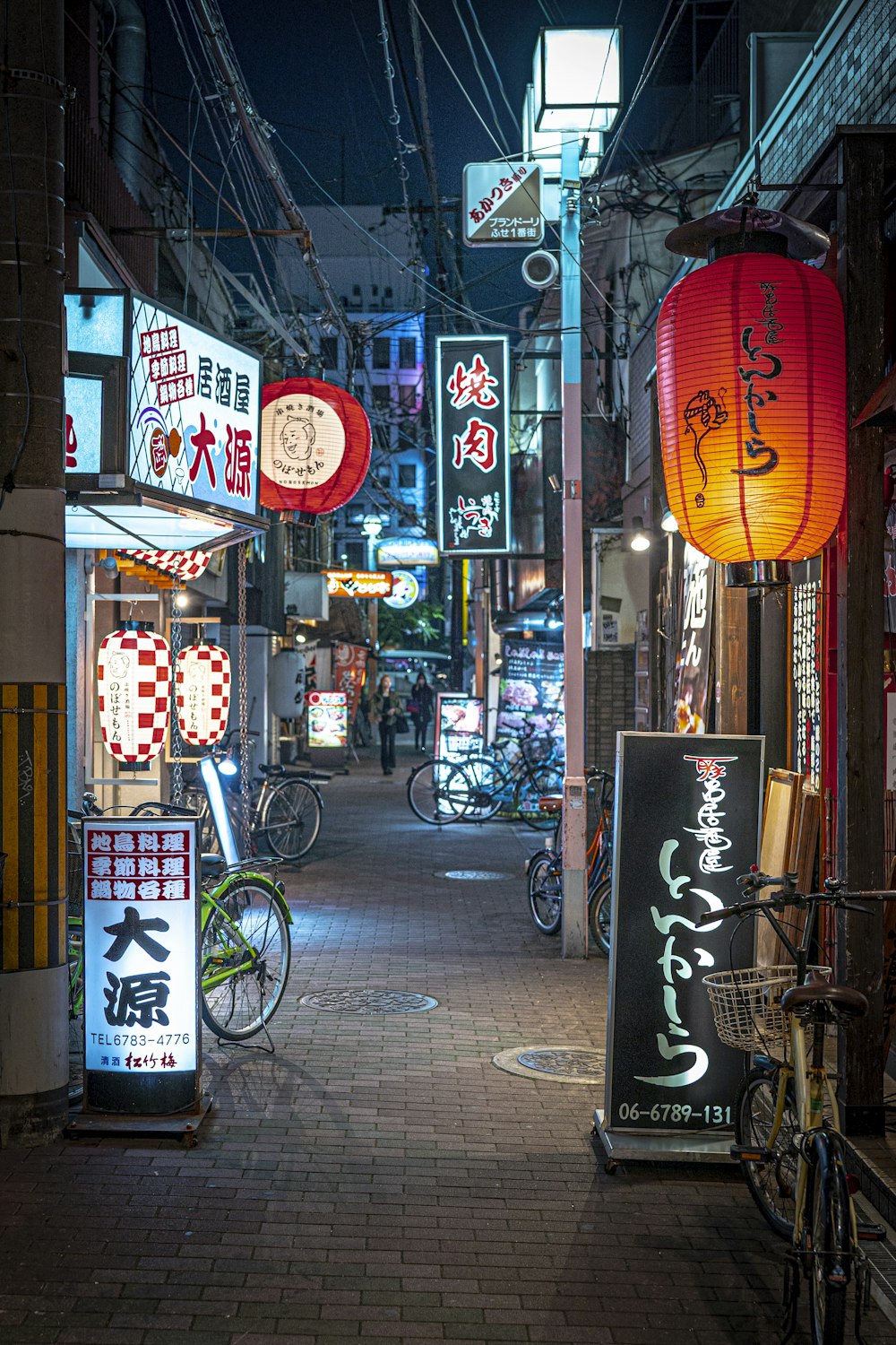 a narrow street with signs and bicycles parked on the side of it