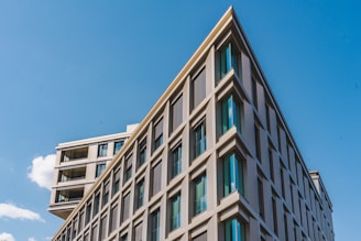 Modern residential building exterior with clean lines and large windows under a clear sky.
