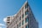 Modern residential building exterior with clean lines and large windows under a clear sky.