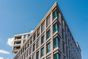 Completed modern residential building with clean architectural lines under blue sky.