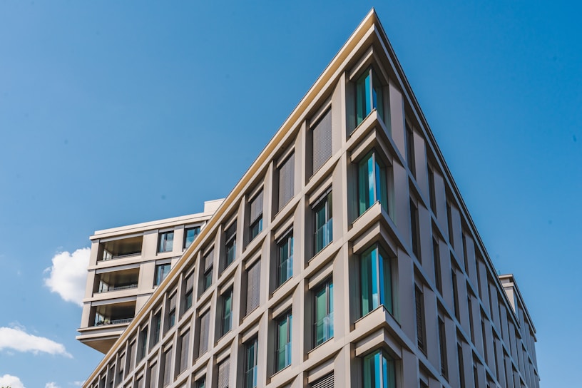A crisp photo of a freshly completed modern residential building with clean lines and blue accents under a bright sky.
