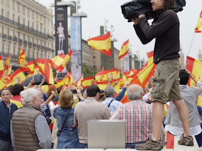 Venezuelan citizens watching news coverage on their smartphones in a public square.
