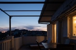 Evening view of the renovated balcony lit softly, inviting relaxation and outdoor enjoyment.