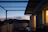 Cozy terrace house balcony with warm evening lights and a view of Melaka’s skyline.