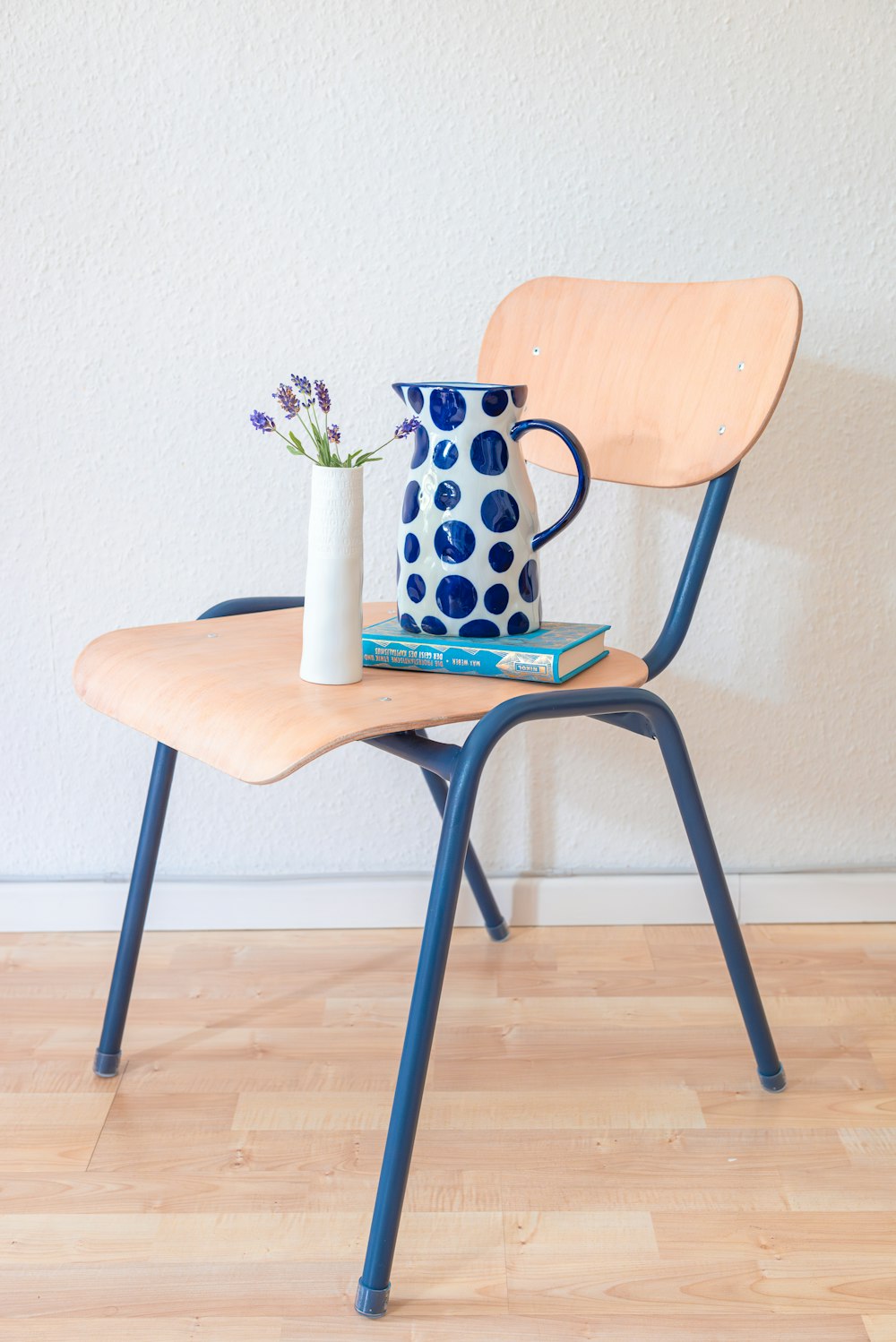 a blue and white vase sitting on top of a wooden chair