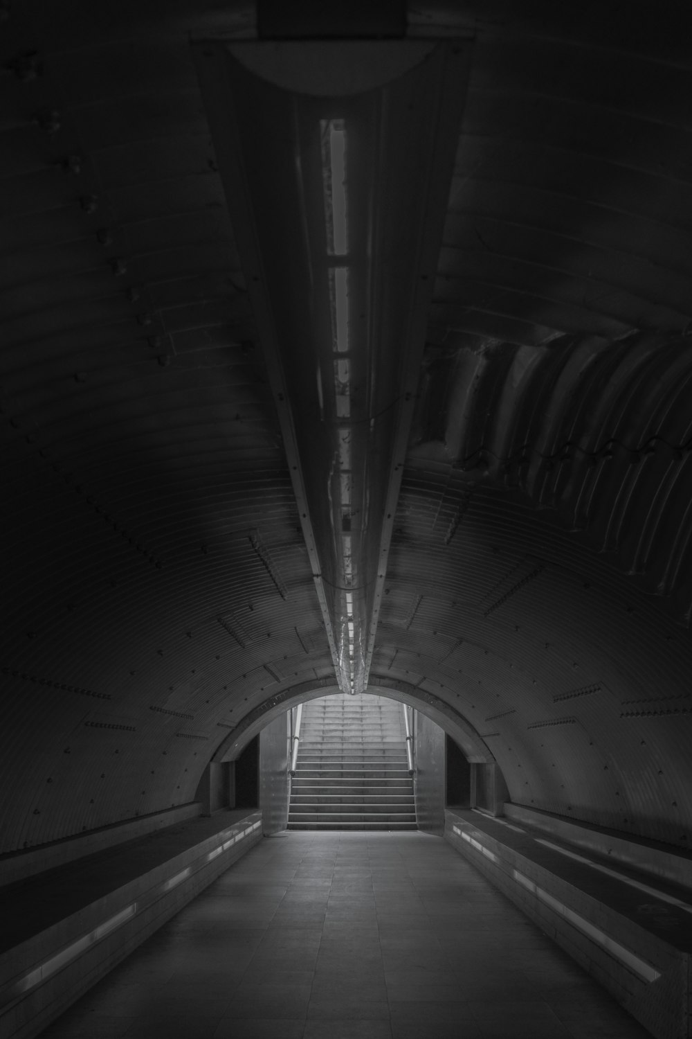 a dark tunnel with stairs leading up to it