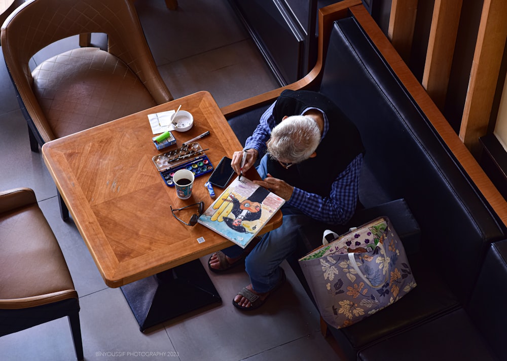 a person sitting at a table with a book