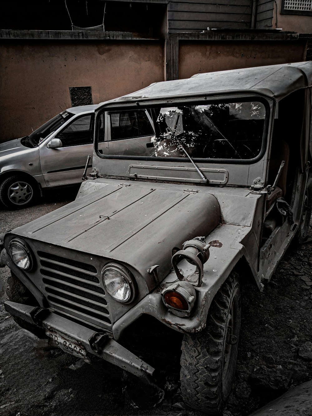 an old jeep is parked on the side of the road