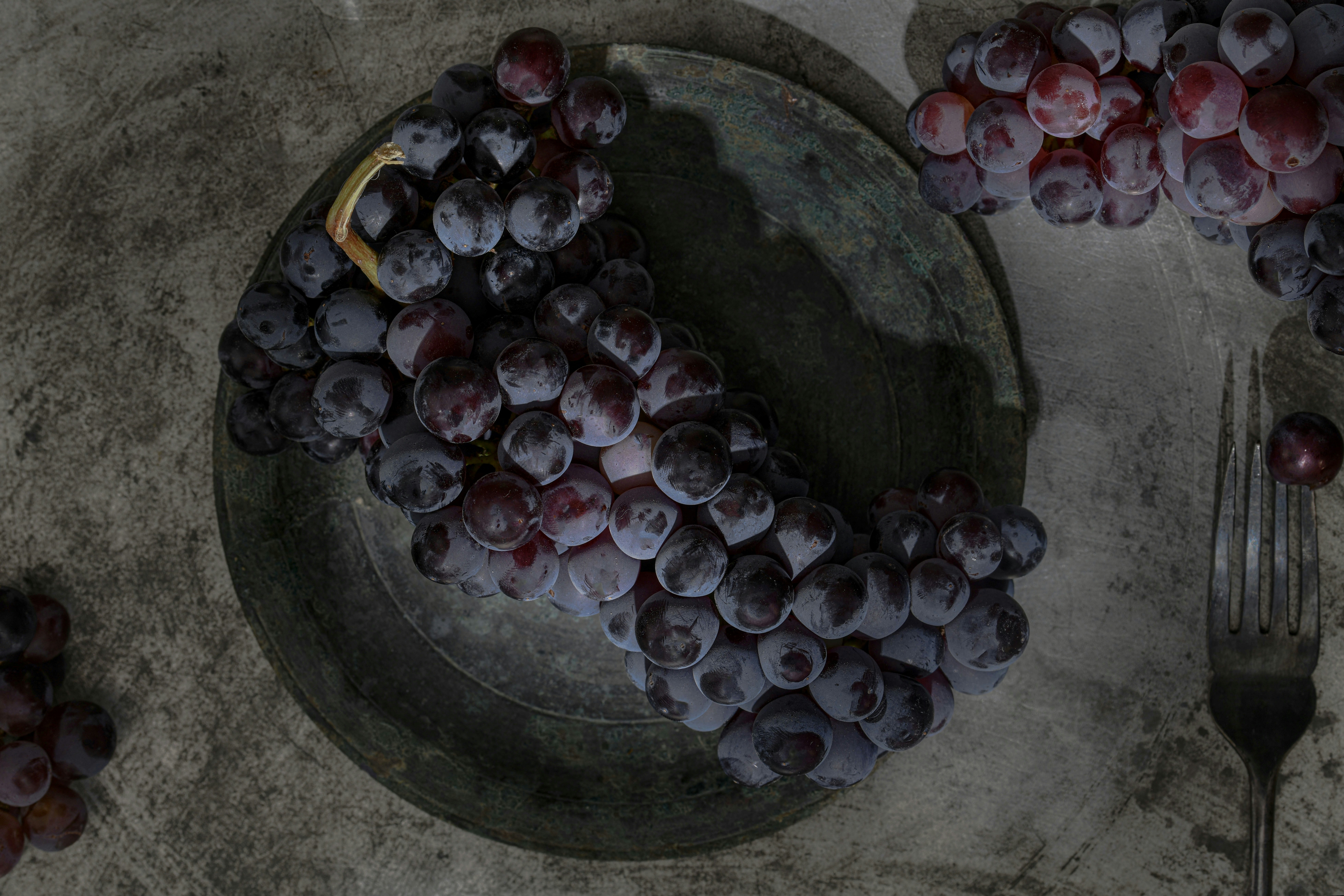 a bunch of grapes sitting on top of a plate