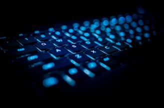 Close-up of a glowing keyboard with blue and violet backlight matching the actarix shop brand colors.