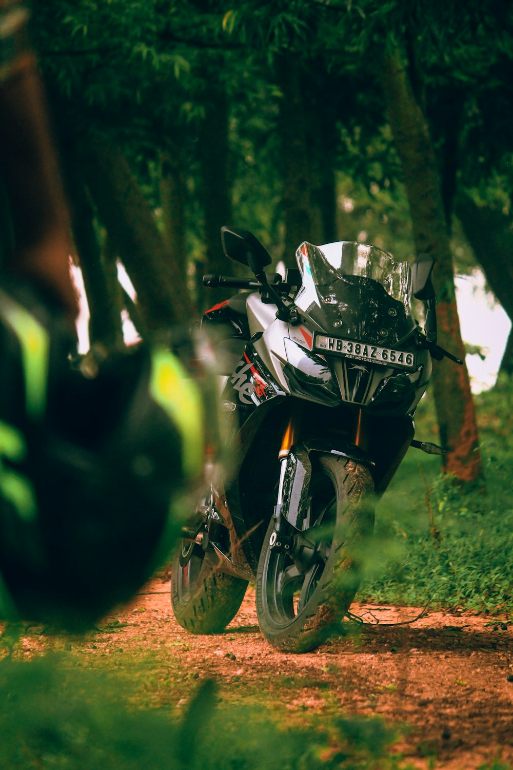 a motorcycle parked on a dirt road in the woods