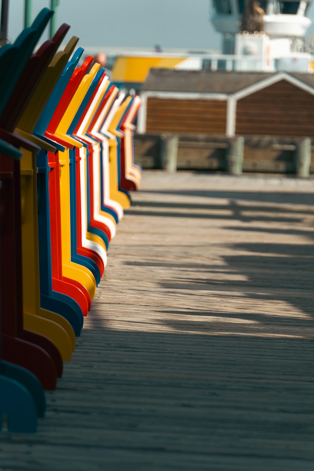 a row of colorful beach chairs sitting on top of a pier