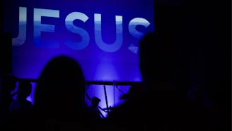 a group of people standing in front of a large screen