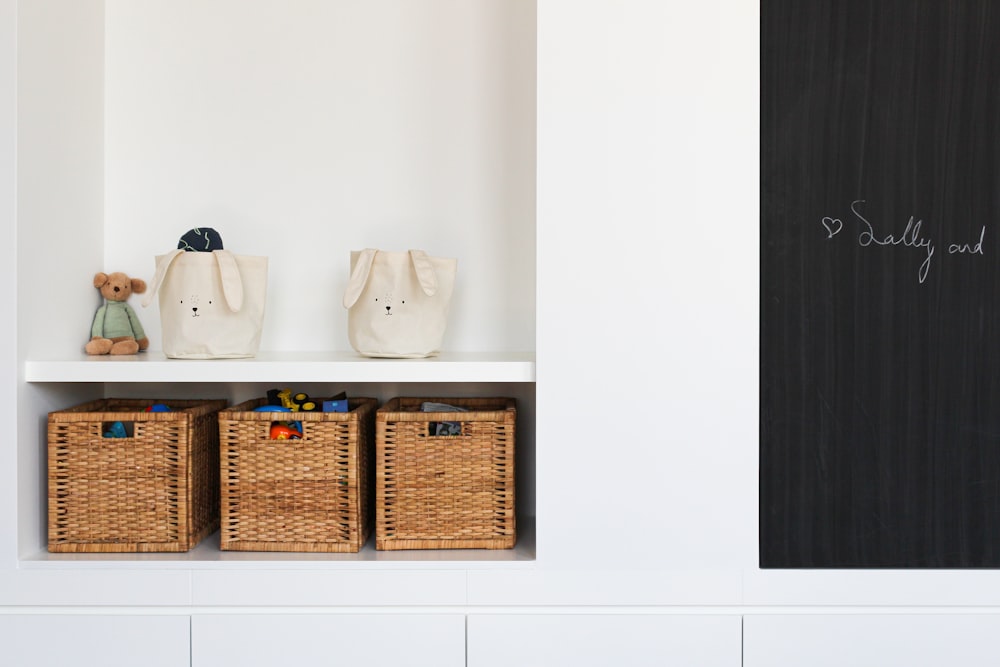 a shelf with baskets and a teddy bear on it