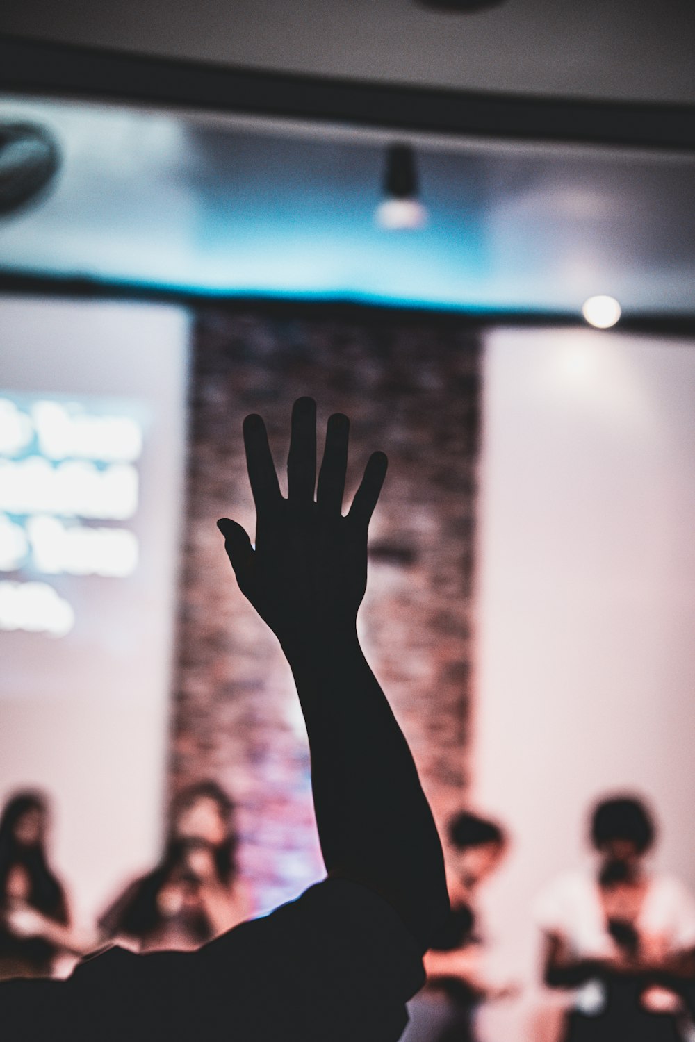 a person raising their hand up in front of a crowd