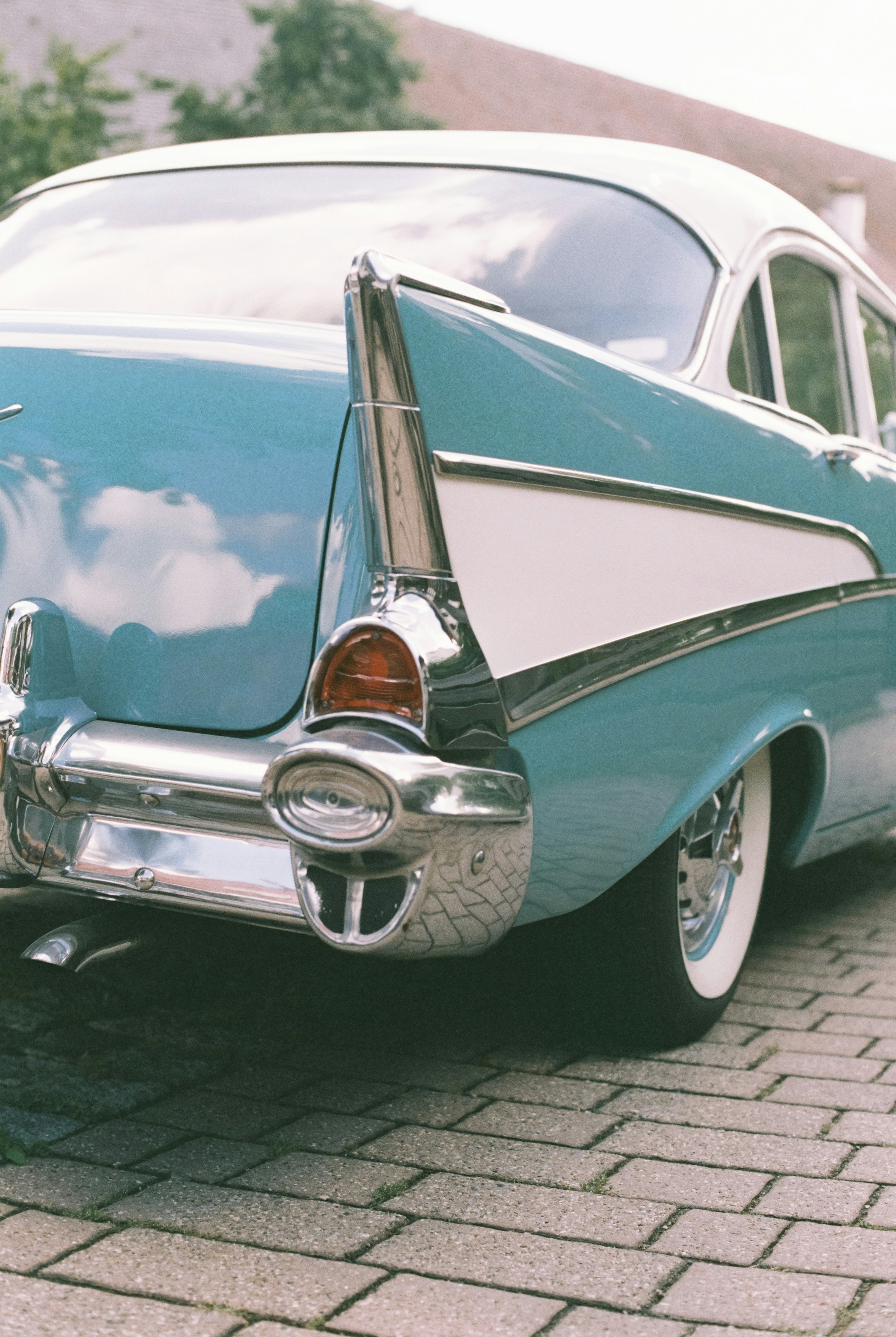 a blue and white car parked on a brick road